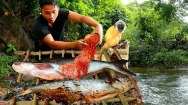 Survival in the rainforest - Man and yellow monkey find food in water meet fish - Eating delicious